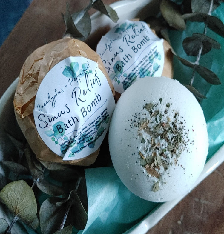 three sinus relief bath bombs in a mini ceramic tub with dried herbs