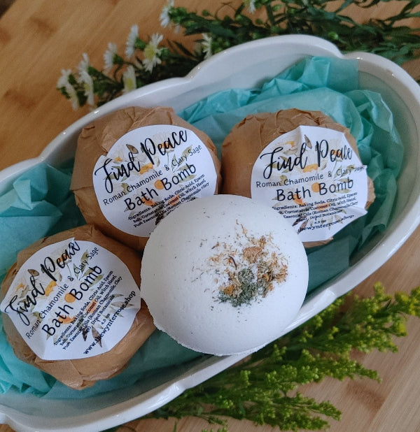 ceramic tub with four find peace bath bombs with fresh flowers on a qooden surface