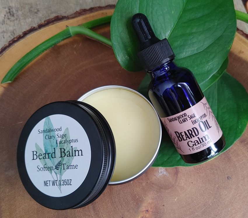 Beard balm and beard oil on a wooden surface with green leaves
