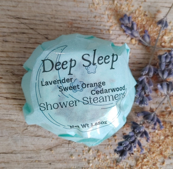 sweet orange lavender and cedarwood essential oil blend shower steamer. dried orange and lavender sprig on a wooden backdrop