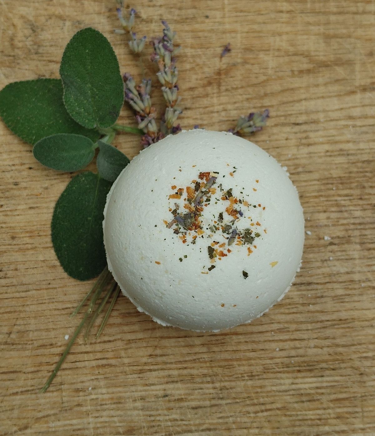 plant based Bath bomb with herbs on a wooden surface from the wynter rose bath collection