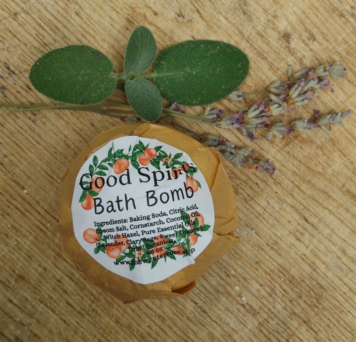 lavender clary sage and sweet orange essential oil Bath bomb with a label on a wooden surface with leaves and flowers
