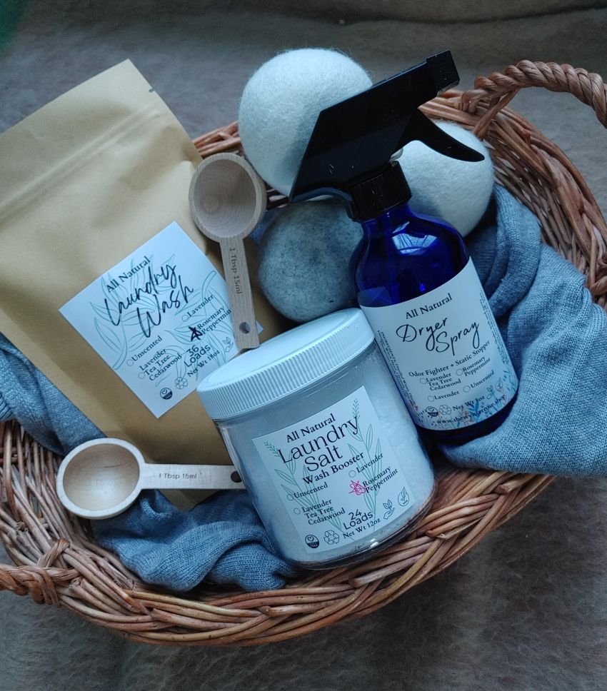 Basket with all-natural laundry products including laundry wash, dryer spray, and laundry salt.