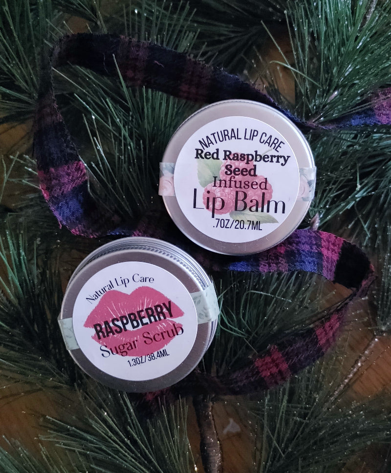 raspberry lip scrub christmas gift Two lip care products on a decorative ribbon with a Christmas tree background