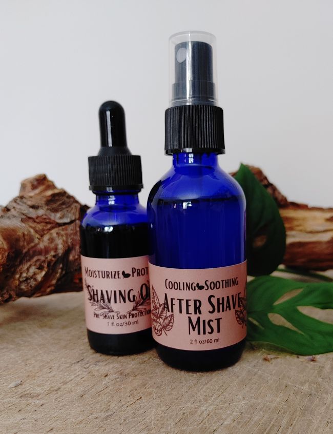 Two bottles of shaving products on a wooden surface with leaves in the background