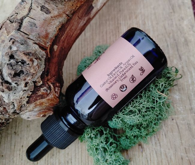 Bottle of essential oil with a label on a wooden surface