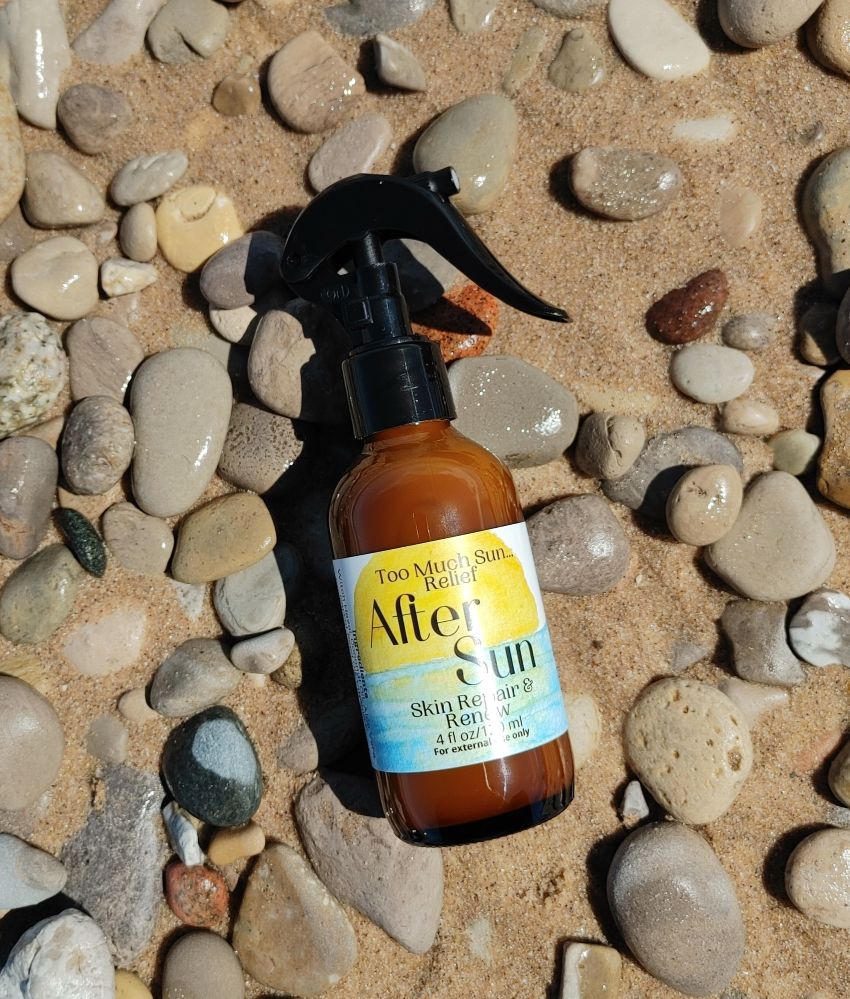 all natural sunburn relief spray sun care skin collection brown glass bottle on beach stone sleeping bear dune beach in glen arbor michigan