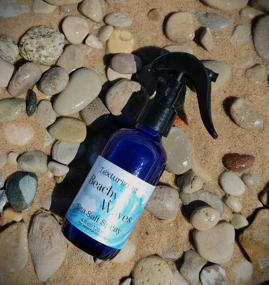 beachy waves sea salt hair spray for beach wave hair sandy michigan beach with beach stone background in blue glass bottle fresh water beach waves