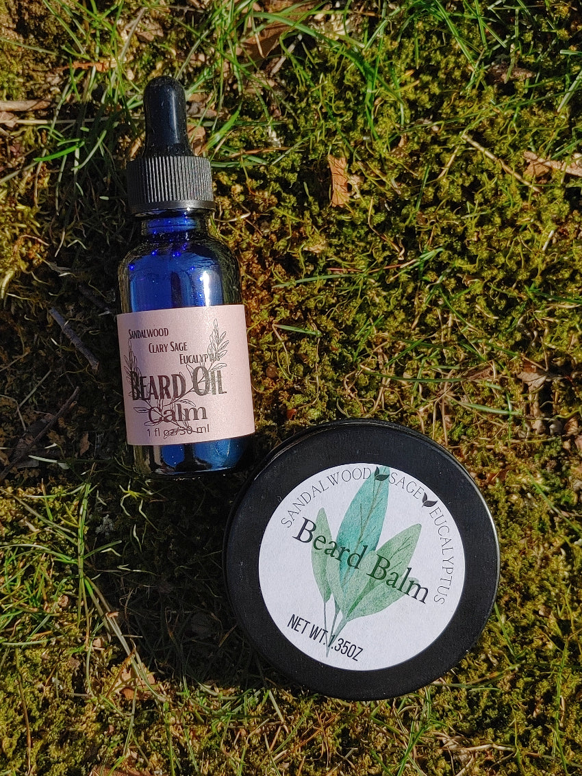 calm beard oil with beard balm in blue glass dropper bottle and black tin on green grass