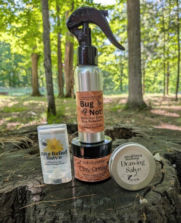 Collection of natural bug relief products on a tree stump in a forest setting