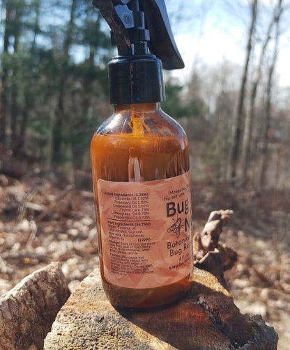 Bottle of Botanical Bug Repellent on a rock with a forest background