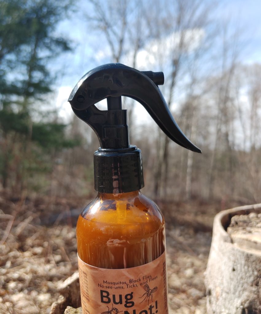 Bug spray bottle with a label in an outdoor setting