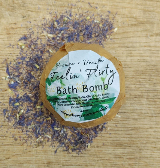 feelin' flirty all natural Bath bomb with a label on a wooden surface with dried lavender flowers