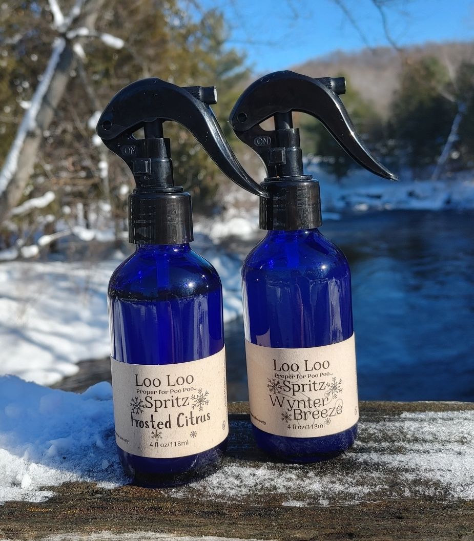 Two blue spray bottles with labels on a snowy surface with a blurred natural background