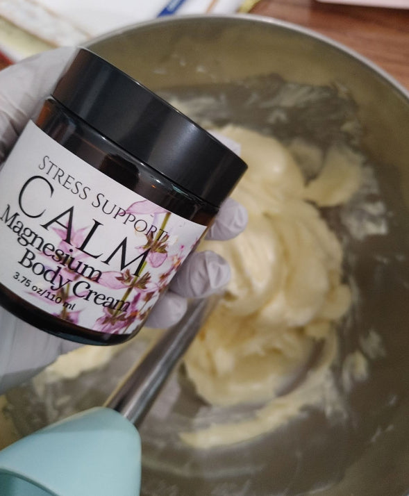 fresh batch of infused Magnesium Body Cream in a jar displayed over with a spatula and bowl 