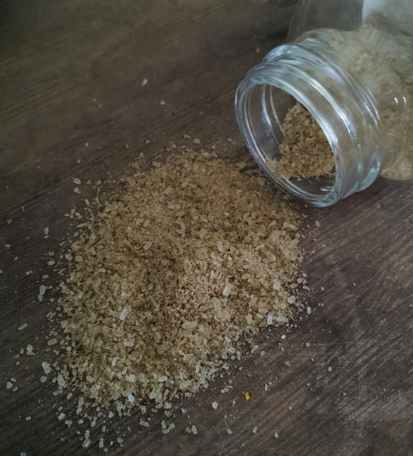Matcha infused body soak by the wynter rose Glass jar of brown sugar on a wooden surface