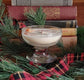 soy wax candle orange essential oil Glass bowl with a candle on a decorative background with books and greenery