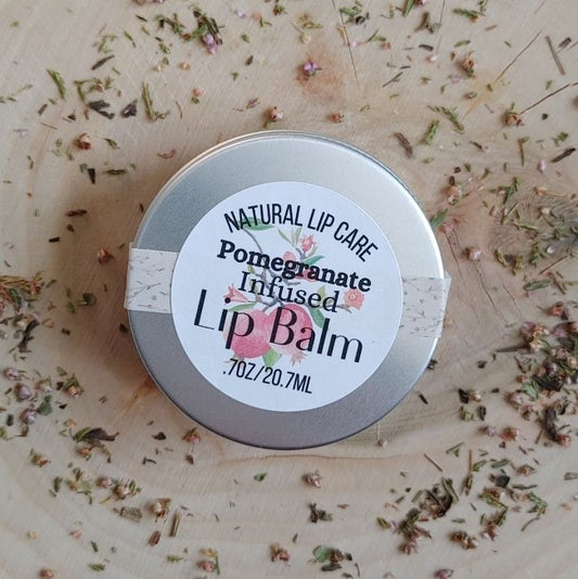 infused all naural lip balm pomegranate lip care in a tin with a wooden background